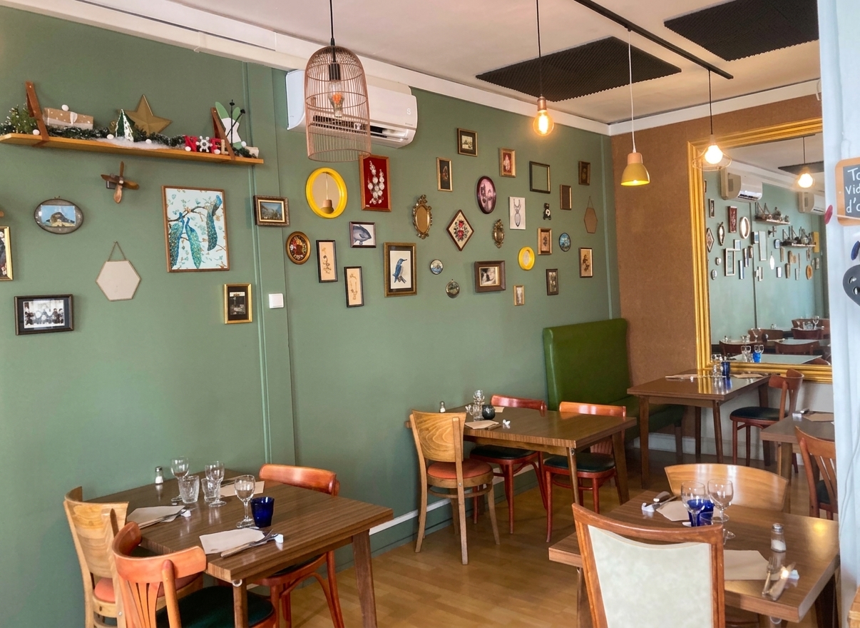 Salle du restaurant avec tables en bois et mur vert aux cadres animaliers, Chez les Filles Saintes